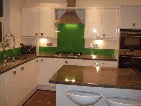 Modern kitchen with granite worktops and glass splash backs installed by Aqua Systems